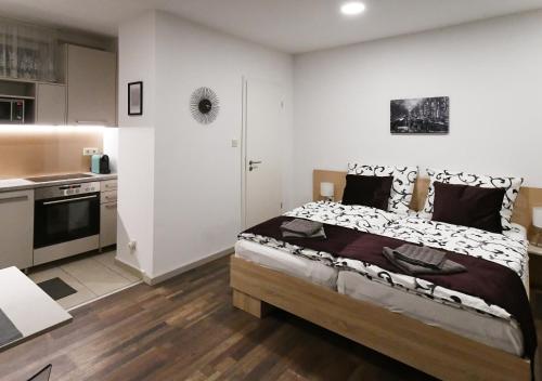een slaapkamer met een bed en een keuken bij Nice Home Apartment 2 in Abda
