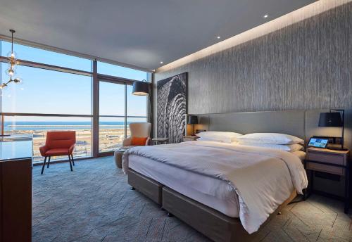 1 dormitorio con cama grande y ventana grande en Mysk Al Mouj Hotel, en Mascate