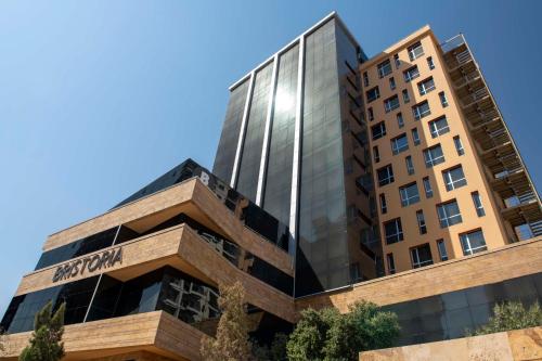 a building in front of a blue sky at Bristoria Hotel Erbil in Erbil