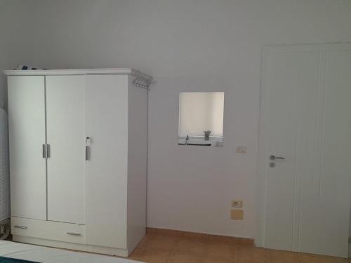 a white room with a white cabinet and a door at Lavender Home in Golem