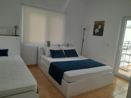 a bedroom with a large white bed with blue pillows at Lavender Home in Golem