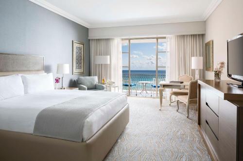 Habitación de hotel con cama y escritorio con TV. en Kempinski Hotel Cancun, en Cancún