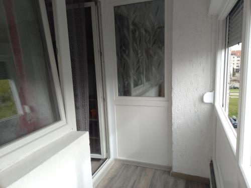 uma porta branca num quarto com duas janelas em Apartman Ciblja em Velika Gorica
