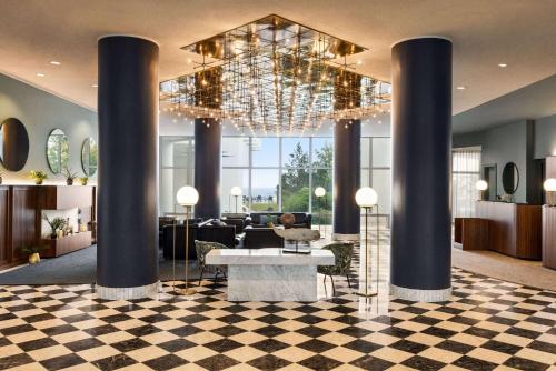 a lobby with a chandelier and a checkered floor at Vienna House by Wyndham Amber Baltic Miedzyzdroje in Międzyzdroje