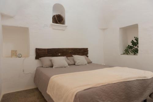 een slaapkamer met een groot bed met witte muren bij Trullo Nonno Marco 2.0 in Cisternino