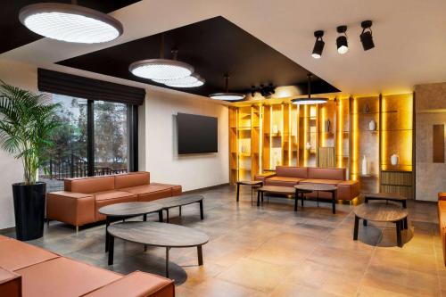 タシュケントにあるRamada Encore by Wyndham Tashkentのソファとテーブルが備わる待合室