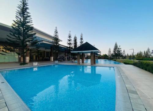 a large blue swimming pool in front of a building at Wind Residences Tower 2 Tagaytay in Tagaytay