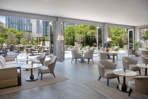 a restaurant with tables and chairs and windows at Kempinski The Boulevard Dubai in Dubai
