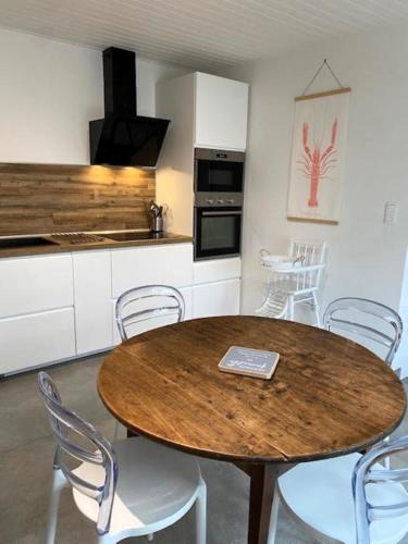 une cuisine avec une table et des chaises en bois dans l'établissement La Lezardiere a deux pas des quais, à Les Sables-dʼOlonne