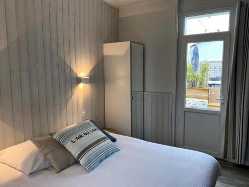 une chambre avec un lit blanc avec une fenêtre dans l'établissement La Lezardiere a deux pas des quais, à Les Sables-dʼOlonne