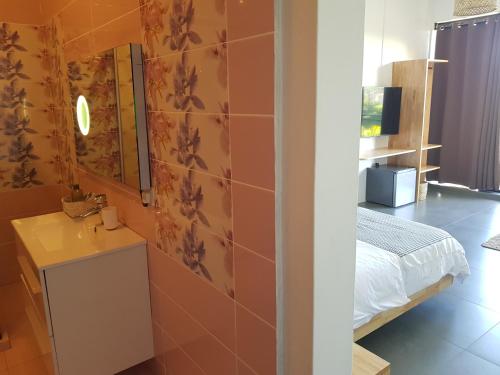 グランベにあるVillas Rocher - Junior Suite 3Bのベッドルーム1室(ベッド1台、壁掛け鏡付)