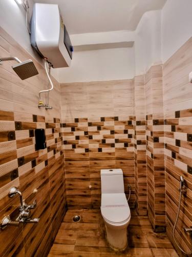 a bathroom with a toilet and wooden walls at Hotel Sangam View in Prayagraj