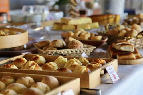 a table with trays of pastries and other baked goods at Pousada Tajupá in Pirenópolis