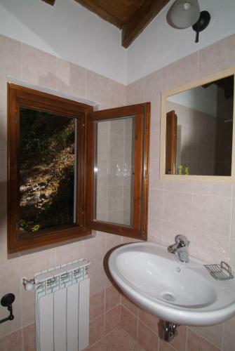 a bathroom with a sink and a window and a mirror at B&B Podere Bramapane in Montelungo Superiore