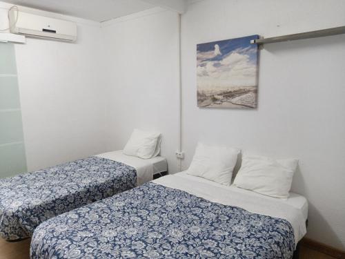 Habitación con 2 camas y una foto en la pared. en Pension Casa De Barca, en Barcelona