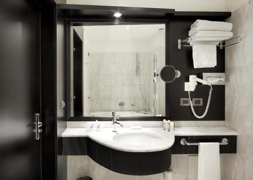 a bathroom with a sink and a mirror at Il Principe Hotel Catania in Catania