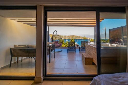 a glass door leading to a patio with a view of the ocean at Nakas Suites in Fethiye