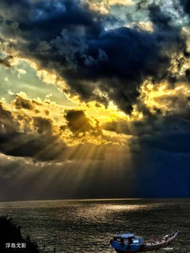 a boat in the ocean under a cloudy sky at B&B of Blueshine in Beigan