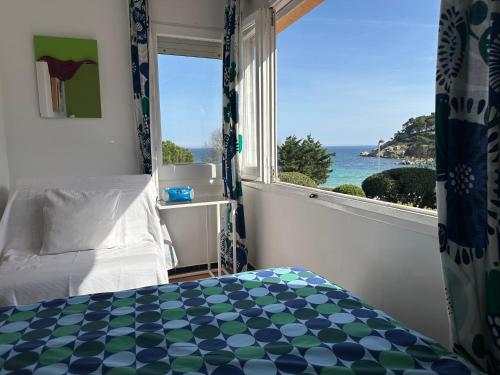 una camera da letto con finestra affacciata sull'oceano di Casa con jardín a 25 metros de la playa. LA T. a Palamós