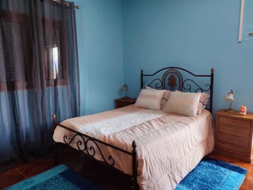 Schlafzimmer mit einem Bett mit blauer Wand in der Unterkunft Vivenda Casa da Fraga in Alijó