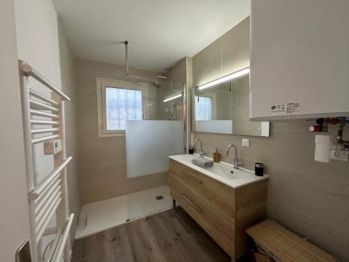 une salle de bain avec un lavabo et un miroir dans l'établissement Villa pour des vacances en famille (linge inclus), aux Mathes