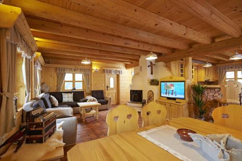 a living room with a couch and a tv in a house at Holiday chalet "Alpine dreams" in Solčava