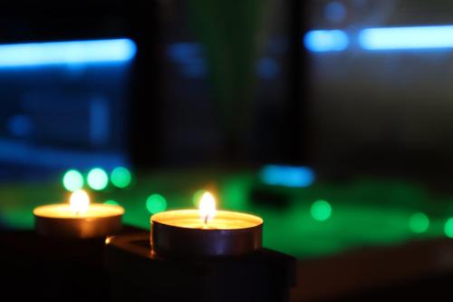 two candles in a dark room with green lights at Barackos Wellness Villa Fót in Fót