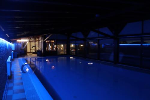 a swimming pool at night with blue lighting at Barackos Wellness Villa Fót in Fót
