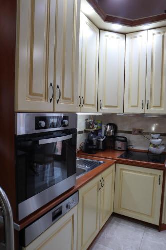 a kitchen with white cabinets and a black oven at Barackos Wellness Villa Fót in Fót