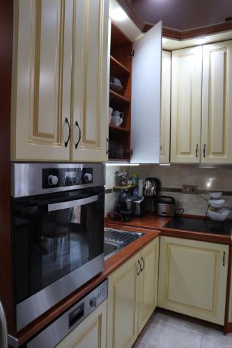 a kitchen with white cabinets and a black oven at Barackos Wellness Villa Fót in Fót