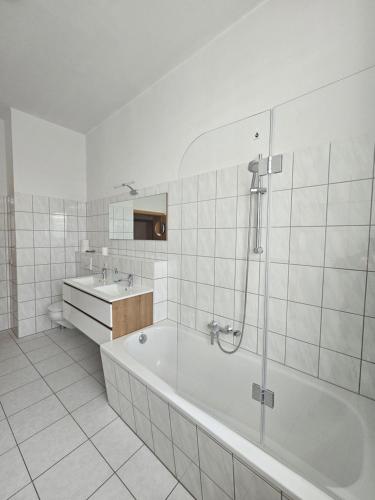 Baño blanco con bañera y lavamanos en Westend 2, en Plauen