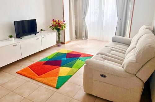 uma sala de estar com um sofá e um tapete colorido em URBAN Apartment - Slatina City Centre em Slatina