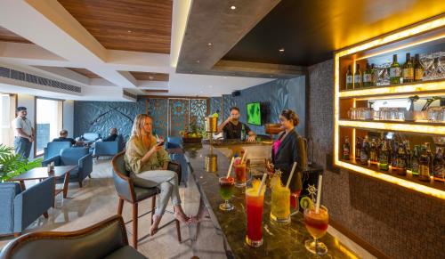 a group of people sitting at a bar in a restaurant at The Grand Cliff Resort Munnar in Viripara