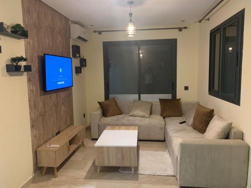 een woonkamer met een bank en een tv bij Appartement meublé à Casablanca in Casablanca