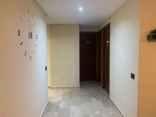 un couloir avec une horloge sur le mur et une porte dans l'établissement Appartement meublé à Casablanca, à Casablanca