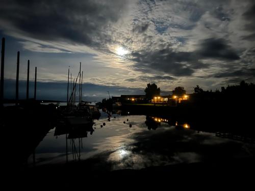 a full moon rising over a marina at night at Valleviken Hotell in Valleviken