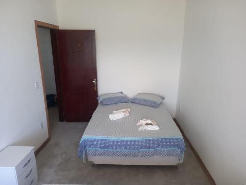 a bedroom with a bed with towels on it at Pousada Pé Na Areia in Arraial do Cabo