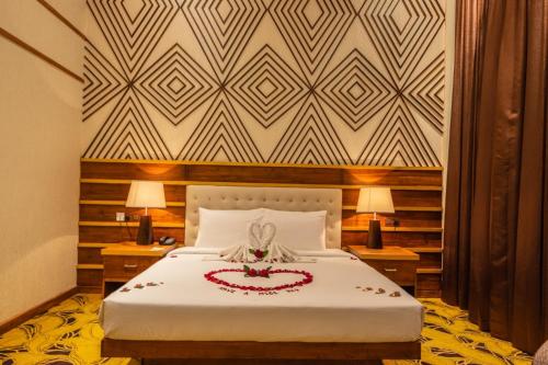 a bedroom with a bed with a flower arrangement on it at The Epitome in Kurunegala