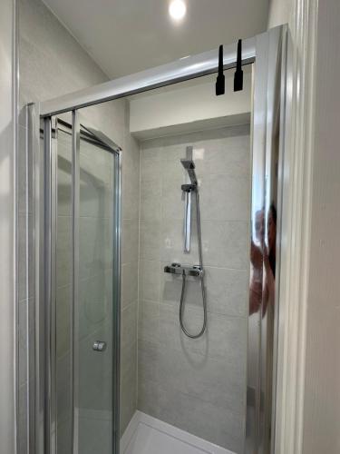 a shower with a glass door in a bathroom at Tiny but private & best Location in London