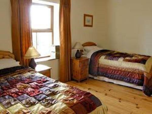 um quarto com 2 camas e uma janela em Trinity Lodge on Lakeshore with Horses, Jetty & Games Room em Boyle