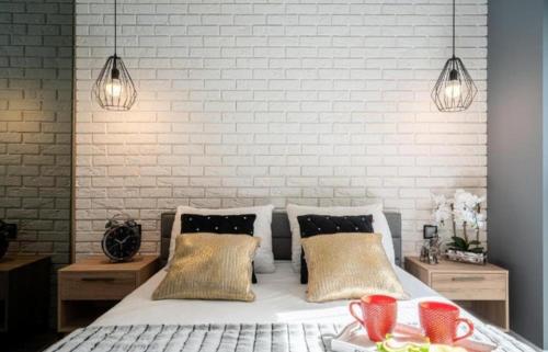 - une chambre avec un lit avec deux tables et deux lumières dans l'établissement Reynk aparts, à Wrocław