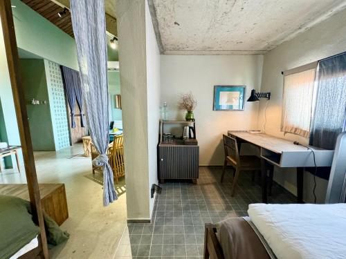 a room with a desk and a bed and a desk at Kaia Gallery Hotel Hoi An in Hoi An
