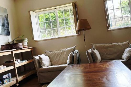 ein Wohnzimmer mit einem Tisch und zwei Stühlen in der Unterkunft Casa Crisa in Marín