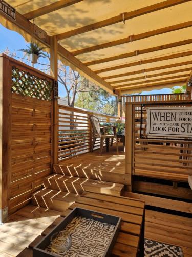 a wooden deck with a wooden pergola at Camping La Carabasse Vias-Plage - T4 Neuf, Tout Confort ! in Vias