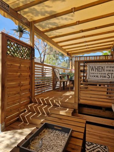 une terrasse en bois avec une pergola en bois dans l'établissement Camping La Carabasse Vias-Plage-T4 Climatisé,Tout confort, Emplacement calme !, à Vias