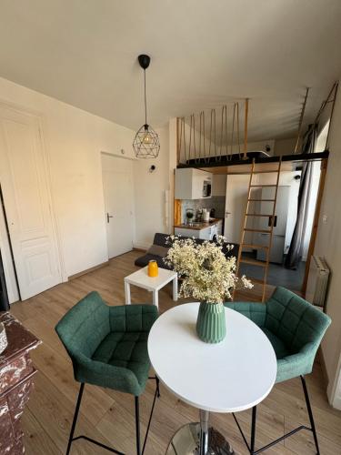 ein Wohnzimmer mit einem weißen Tisch und grünen Stühlen in der Unterkunft Studio hypercentre Tassin La Demi Lune in Tassin-la-Demi-Lune