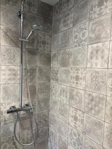 een douche in een badkamer met een tegelwand bij Auberge du Carrefour in Vielsalm
