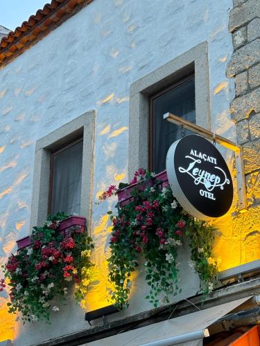 un edificio con dos ventanas con flores y un cartel en Alacati Zeynep, en Alacati