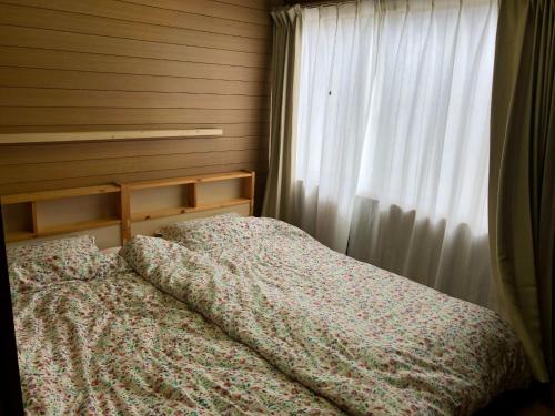 a bed in a bedroom with a curtain and a window at Setouchi base - Vacation STAY 48143v in Mitoyo