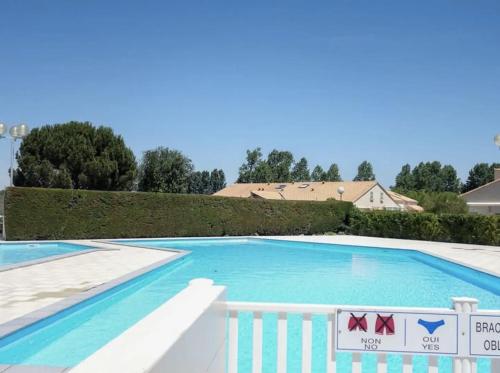 une grande piscine bleue avec une clôture blanche dans l'établissement Villa pour des vacances en famille (linge inclus), aux Mathes